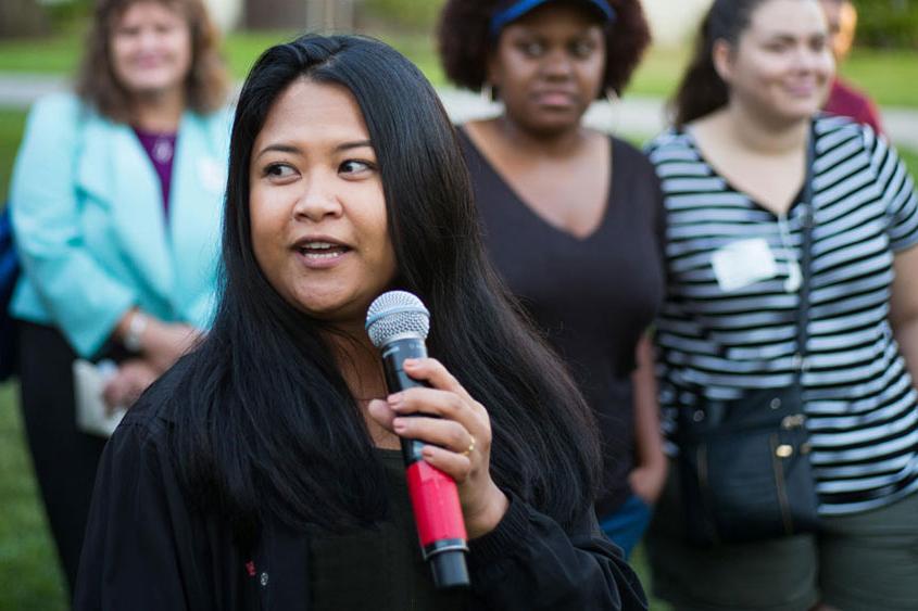 菠菜网lol正规平台 community member holding a mic and talking.